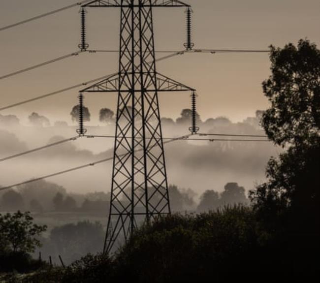 Electrical pylons carry electricity cables across fields